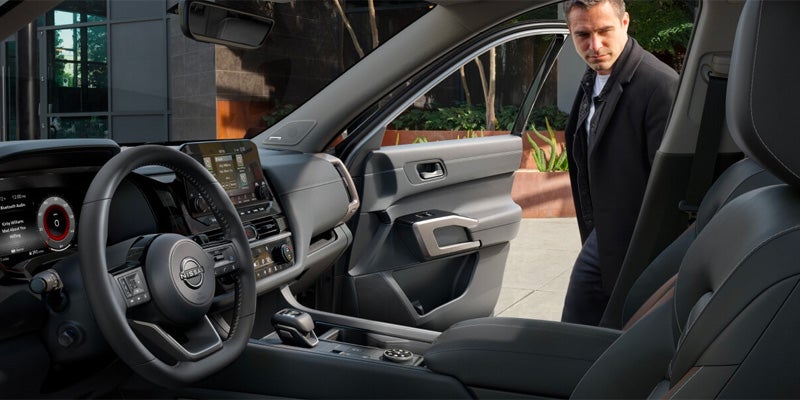 A passenger getting into a 2025 Nissan Pathfinder in Pompano Beach, FL